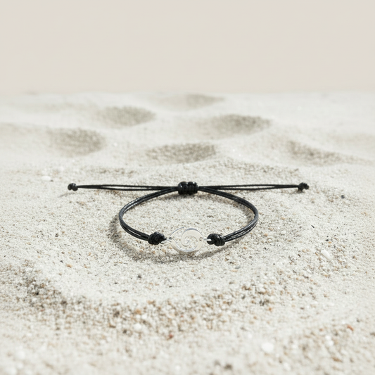 Bracelet noir sur sable blanc